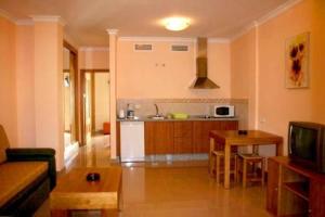 uma cozinha e sala de estar com um sofá e uma mesa em Apartamentos María Del Carmen em Torremolinos