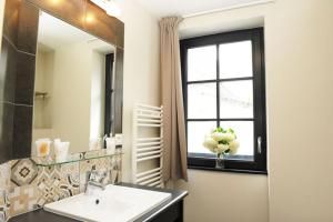 a bathroom with a sink and a window and a mirror at Hôtel Restaurant Corto Maltese in Le Palais