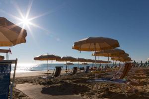 un gruppo di sedie e ombrelloni in spiaggia di Hotel Miramare a Pineto