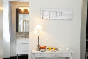 a bathroom with a table with a lamp and a sink at Hôtel Restaurant Corto Maltese in Le Palais