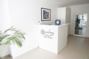 a white reception desk in a room with a plant at Gattini33 in Matera