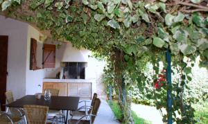 una cocina con mesa y sillas bajo un árbol en Mini Villa Santa en Porto Vecchio