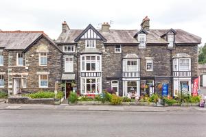 een groot bakstenen gebouw met bloemen ervoor bij 3 Cambridge Villas in Ambleside