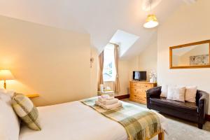 1 dormitorio con 1 cama y 1 sofá en 3 Cambridge Villas, en Ambleside