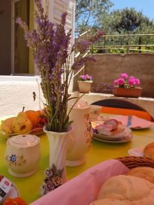 un tavolo con fiori in vaso e piatti di cibo di Apartments Guberina a Šibenik