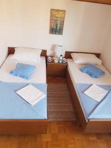 - deux lits assis l'un à côté de l'autre dans une pièce dans l'établissement Apartments Guberina, à Šibenik