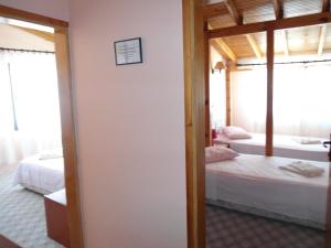 a room with two beds and a door to a bedroom at Teras Motel in Foça