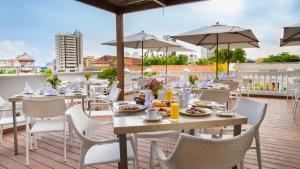 
a dining area with tables, chairs and umbrellas at Arsenal Hotel in Cartagena de Indias
