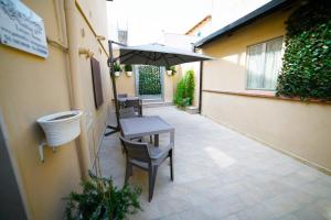 eine Terrasse mit einem Tisch, Stühlen und einem Sonnenschirm in der Unterkunft Gattini33 in Matera