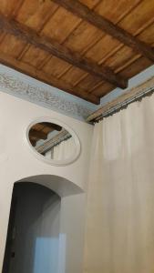 トリノにあるSavoia Aptの白いカーテンと鏡が備わる部屋