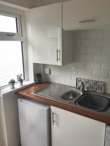 a kitchen with a sink and a counter top at Belfast Holiday Home in Belfast