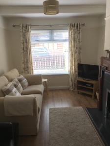 a living room with a couch and a large window at Belfast Holiday Home in Belfast