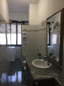 トリノにあるAppartamento Bengasiのバスルーム(洗面台、鏡付)