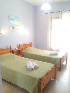 a room with two beds and a window at Nikos Apartments in Sidari