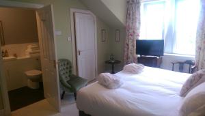 a bedroom with a white bed and white walls at Lochinver Guesthouse in Ayr