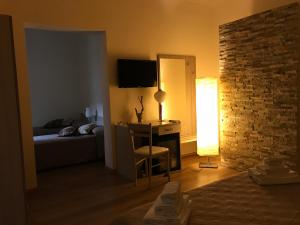 ein Schlafzimmer mit einem Bett und einem Schreibtisch mit einer Lampe in der Unterkunft Papali in Catania