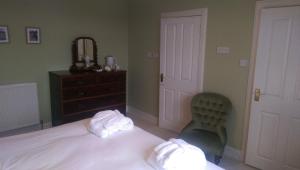 a bedroom with a bed and a dresser at Lochinver Guesthouse in Ayr