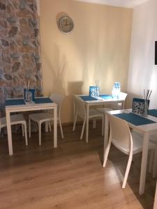 ein Zimmer mit Tischen und Stühlen und einer Uhr an der Wand in der Unterkunft Papali in Catania