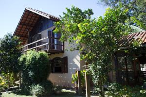 a house with a tree in front of it at Pousada Montserrat in Visconde De Maua