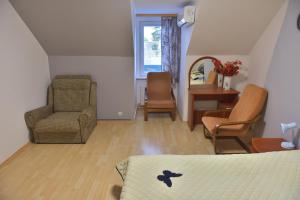 um quarto com uma cama, uma cadeira e uma mesa em Jurmala Guest House Markiza em Jūrmala