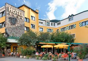 a hotel with people sitting at tables in front of it at Hotel Schrofenstein in Landeck