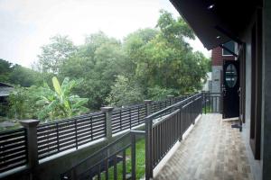 a balcony of a building with a fence and trees at PK Villa Huahin in Hua Hin