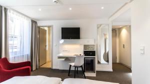 een hotelkamer met een bed, een bureau en een keuken bij Bayerischer Hof in Kitzingen