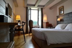 sypialnia z łóżkiem, biurkiem i oknem w obiekcie La Maison Des Jardins w mieście Auriac