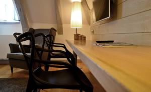 a desk with two chairs and a table with a lamp at La Maison Des Jardins in Auriac