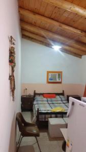 una camera da letto con un letto e una sedia in una stanza di Alquimia a Capilla del Monte