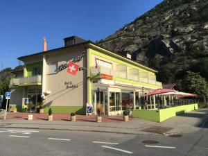 ein Gebäude an der Seite einer Straße mit einem Berg in der Unterkunft Hotel Römerhof in Brigerbad