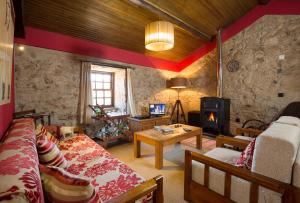 a living room with a couch and a fireplace at Casa Do Ze Sapateiro in Ferraria de São João