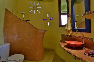 a bathroom with a sink and a toilet and a mirror at Sea View Colorful House in Ilhabela