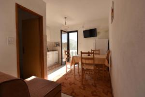 a kitchen and dining room with a table and chairs at Apartmani Marko in Gdinj