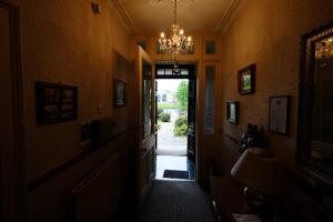 un corridoio con lampadario pendente e un corridoio con porta di Talisker Guest House a Inverness