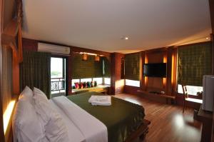 ホアヒンにあるチャレラン ホテル ホアヒンのベッドとテレビが備わるホテルルームです。