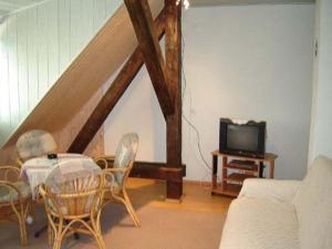 a living room with a table and chairs and a tv at Apartment Park Crni Lug in Crni Lug