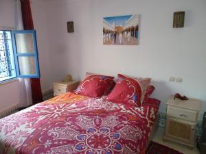 ein Schlafzimmer mit einem Bett und einem Bild an der Wand in der Unterkunft Dar Chebba in Oualidia