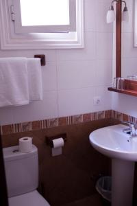 a bathroom with a toilet and a sink and a window at Hostal El Pilar in Madrid