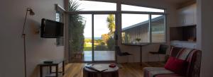 a living room with a couch and a large window at Eagle Peaks at Freycinet in Coles Bay