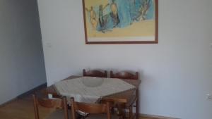 tavolo da pranzo con sedie e una foto appesa alla parete di Apartman Jezidžić a Kaštela (Castelli)