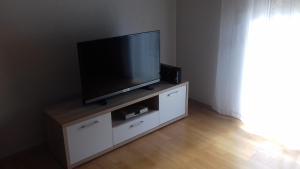 una TV a schermo piatto seduta sopra un armadio di Apartman Jezidžić a Kaštela (Castelli)