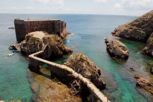 an old building on the rocks in the ocean at Sol e Praia - Peniche II in Peniche