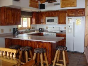 La cuisine est équipée d'un réfrigérateur blanc et de placards en bois. dans l'établissement Walleye Inn Home, à Phelps