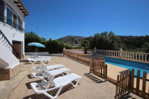 モライラにあるJuliasol - holiday home with private swimming pool in Morairaのスイミングプールのそばのラウンジチェアのグループ