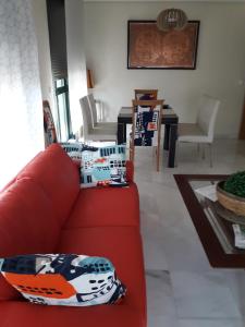 un soggiorno con un divano rosso e un tavolo di Apartamento Las 4 Palmeras a Cordoba Altre 15 foto