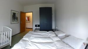 - une chambre avec un grand lit et des draps blancs dans l'établissement Casa Sabrina, à Pugerna