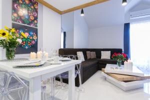 salon z białym stołem i kanapą w obiekcie Giewont Krupówki SPA w Zakopanem