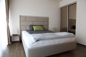 1 dormitorio con cama blanca grande y almohada verde en Sandheiderhof, en Erkrath