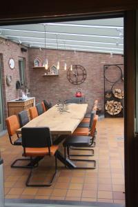 a dining room with a large wooden table and chairs at B&B Het KoeKoeKsnest Schelle in Schelle